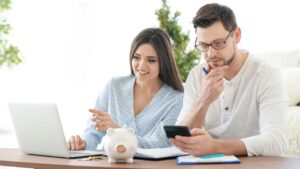 Husband Wife calculating income together on laptop for UK Visa