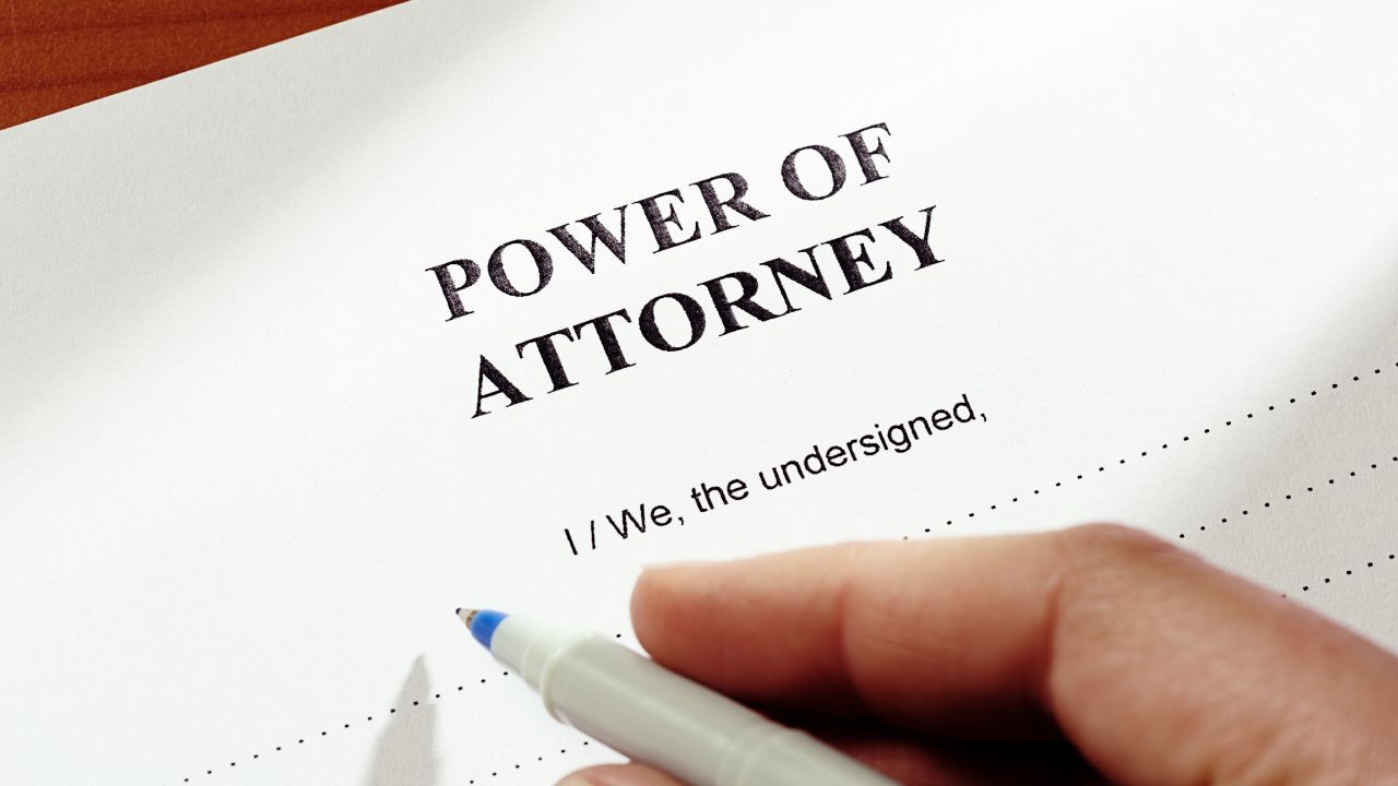 Hand signing a Power of Attorney document.