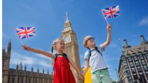 Two children in London holding british flags