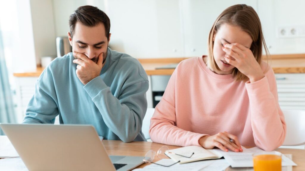 Husband and Wife after receiving refusal on their desk with laptop