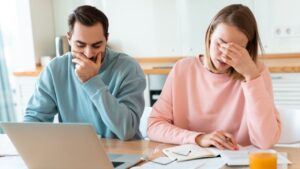 Husband and Wife after receiving refusal on their desk with laptop