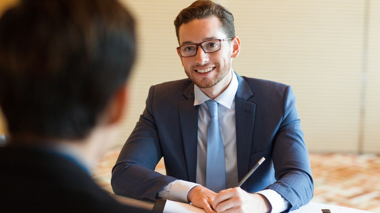 A regulated UK immigration adviser explaining UK visa options to a client across an office desk.