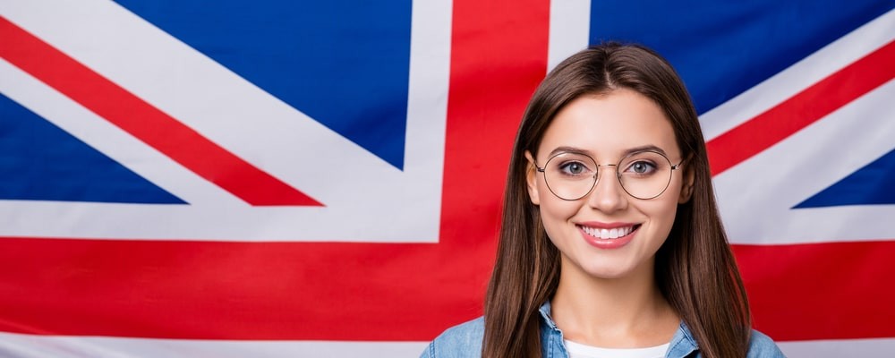 referees-in-british-citizenship-applications-hero Smiling woman giving thumbs up in front of a Union Jack, illustrating referees for a British citizenship application