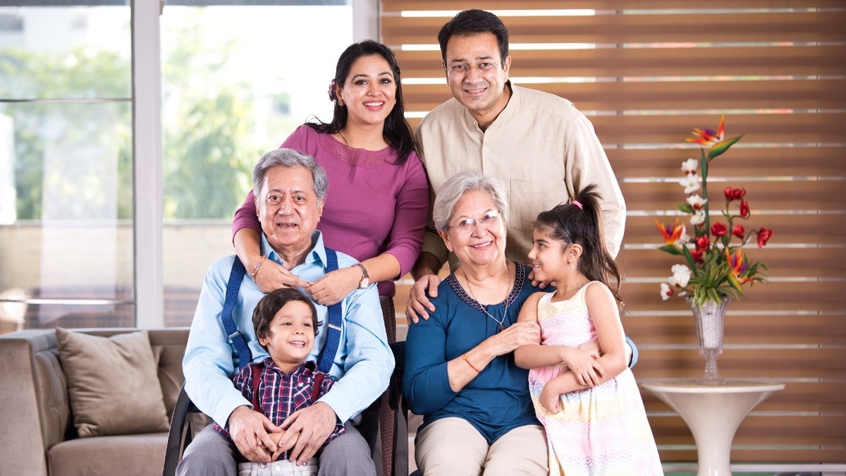 Claim Inherited Property in India Three-generation Indian family posing together in their living room, illustrating how to claim inherited property in India