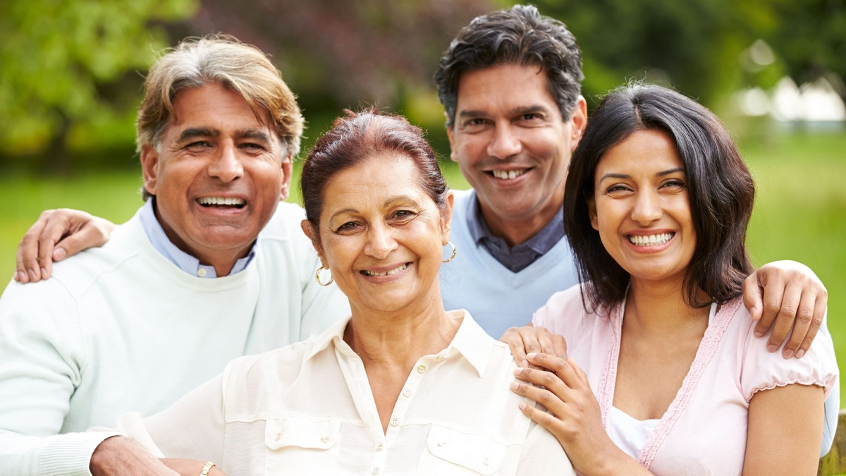 Indian Property Inheritance Smiling Indian family of four across two generations in a garden, illustrating questions NRIs ask about inheriting property in India
