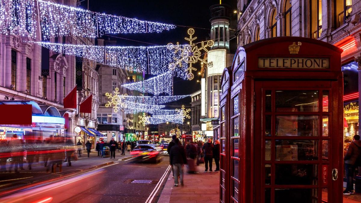 UK Visitor Visa FAQs Red telephone box on a London street lit with Christmas lights at night, illustrating common questions about the UK visitor visa